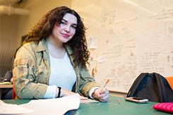 Student sits over cutting mat